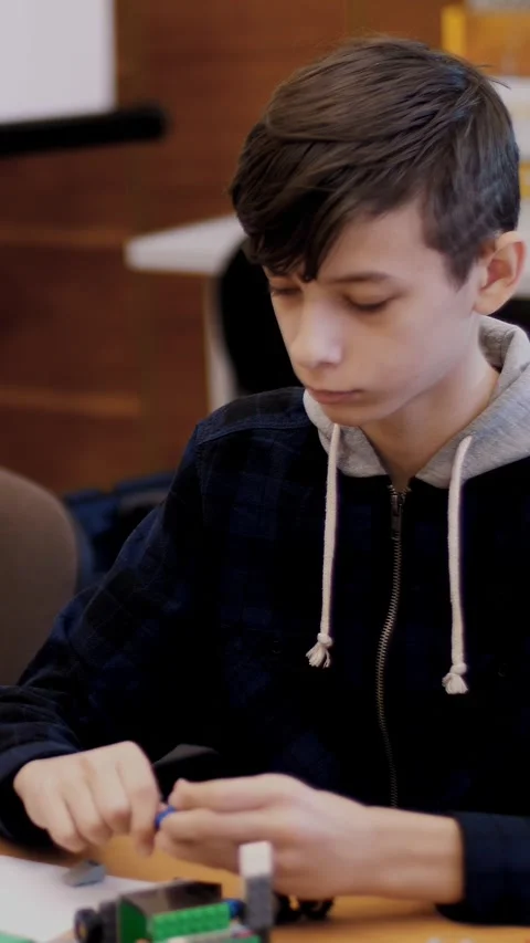 The boy of 12 years, plays in the designer from cubes, plates, circuits, wires. Stock Footage 314791799
