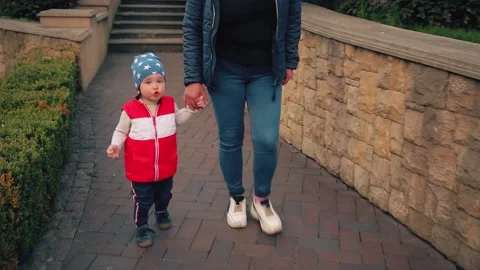 Boy 2 years old, walking with mom in the park. Stock Footage 153559986