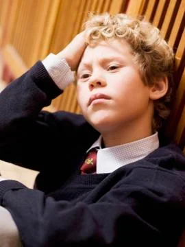 Boy (4-7) leaning on locker, head in hands, close-up Stock Photos