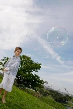 Boy (4-7) playing with soap bubble Stock Photos