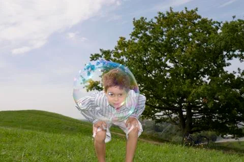 Boy (4-7) playing with soap bubble Stock Photos