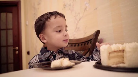 A boy 4 years old eats cake with his hands. Stock Footage 73477586