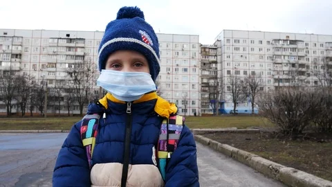 Boy 5-6 years old in a protective mask on the street Stock Footage 123975611