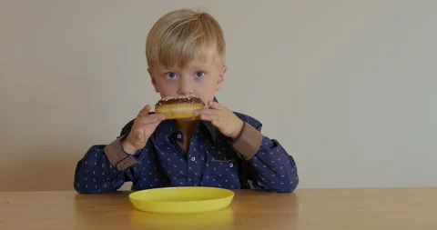 The boy 5 years old eats a sweet donut. 4k 스톡 동영상 282918723