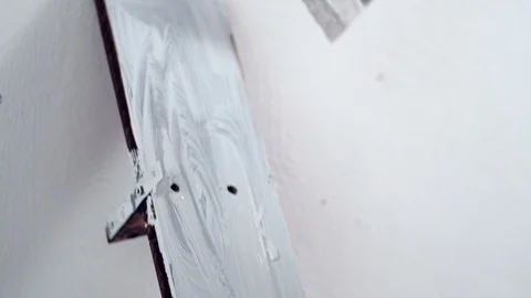 A boy of 5 years old paints a shelf with a white paint. close-up 動画素材 125378750