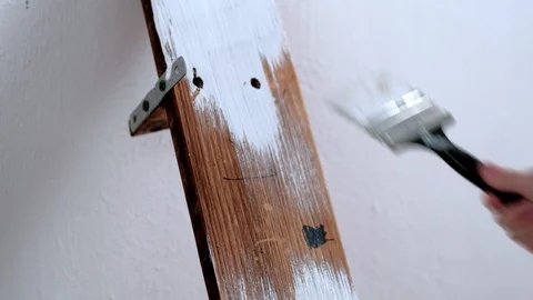 A boy of 5 years old paints a shelf with a white paint. close-up Stock-Footage 125379245