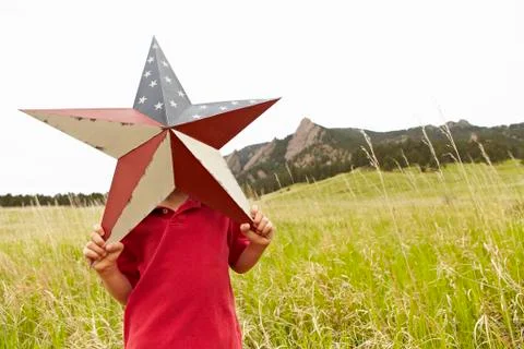 Boy (6-7) playing with star with American flag pattern Stock Photos