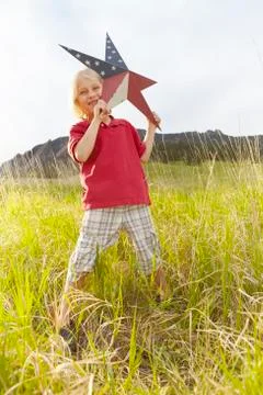 Boy (6-7) playing with star with American flag pattern Stock Photos