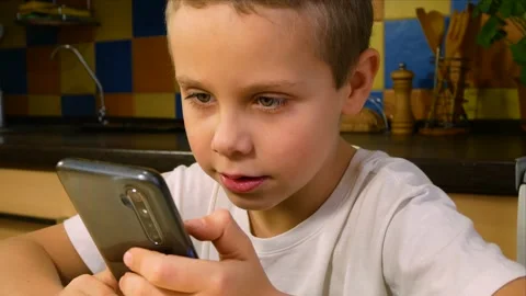 A boy of 6-7 years old plays a game on a gadget Stock Footage 204020459