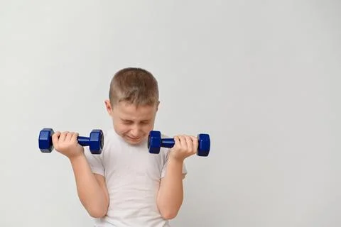 A boy 8-10 years old with dumbbells on a white background. mock up Stock Photos