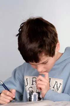 Boy (8-9) doing schoolwork, close-up Stock Photos