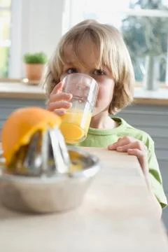 Boy (8-9) drinking fresh orange juice, portrait Stock Photos
