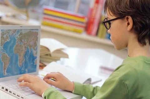 Boy (8-9) using laptop, side view Foto stock