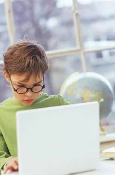 Boy (8-9) using laptop Stock Photos