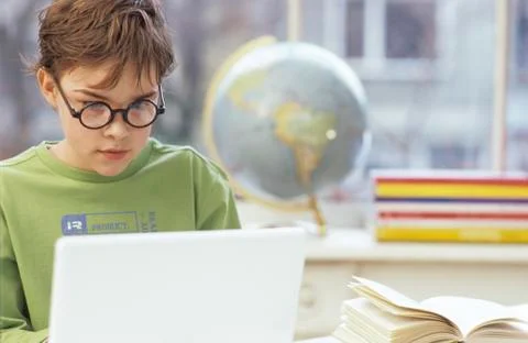Boy (8-9 years) using laptop Stock Photos