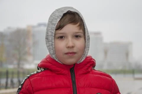 Boy 8 years old, smiling and happy on the background of fog in the city. Stockfoto's