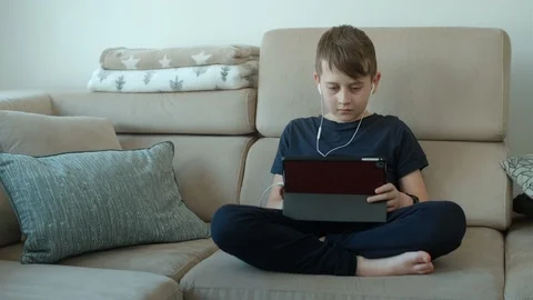 Boy of 8 years old studies lessons on a tablet. Distance education Stock Footage 126958179