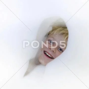 Boy 9 years head amidst bath foam Stock Photos