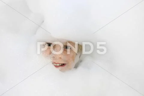 Boy 9 years head amidst bath foam Stock Photos