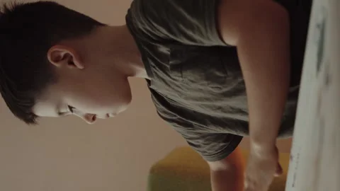 Boy about to draw on a blank paper with colored markers, sitting at a table Stock Footage 270427647