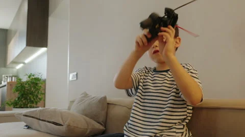 Boy actively playing alone in the living room sitting on the sofa. Video stock 262645852