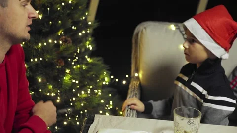 The boy adjusts the garland on the tree. Video stock 220079915
