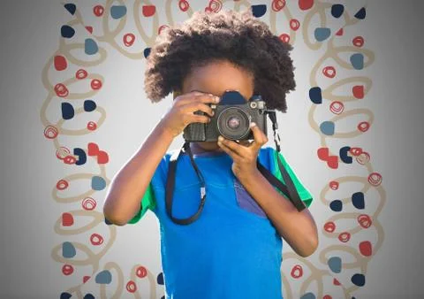Boy against grey background with camera and colorful pattern Stock Photos