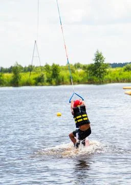 Boy age 9 riding wakeboard on lake Stock Photos