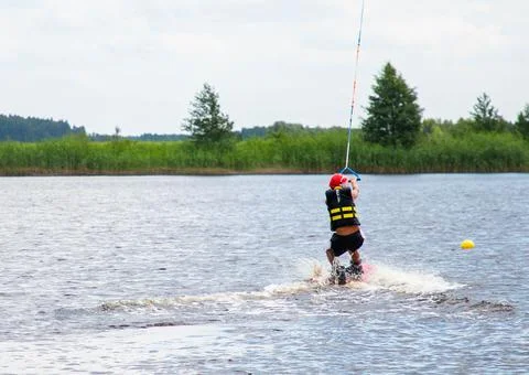 Boy age 9 riding wakeboard on lake Stock Photos