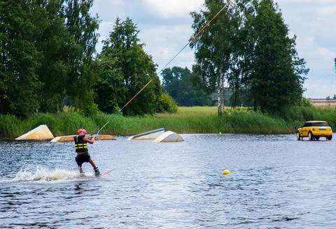 Boy age 9 riding wakeboard on lake Stock Photos