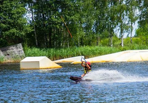 Boy age 9 riding wakeboard on lake Stock Photos
