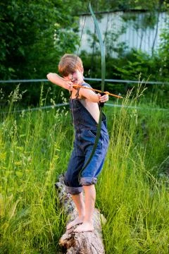 Boy aiming bow and arrow Stock Photos