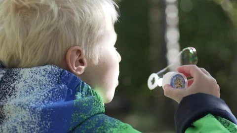 The boy albino blows bubbles. Stock Footage 95830249