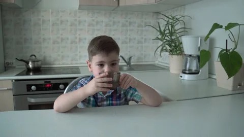 The boy is alone in the kitchen at the table Stock Footage 167590822