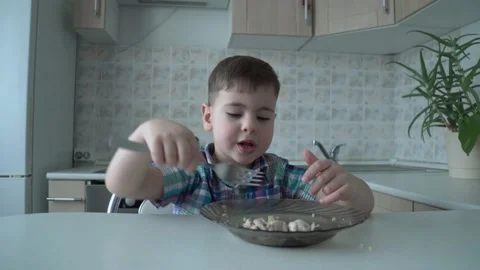The boy is alone in the kitchen at the table Stock Footage 167590833