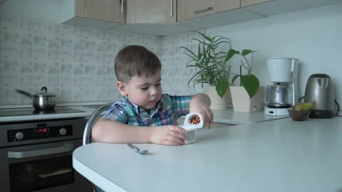 The boy is alone in the kitchen at the table Stock Footage 167590839