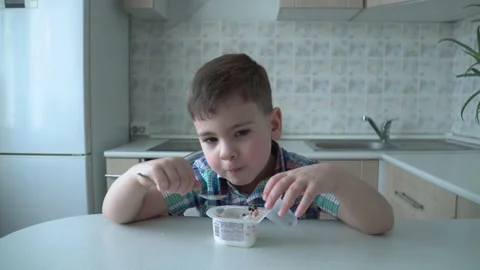 The boy is alone in the kitchen at the table Stock Footage 167590846