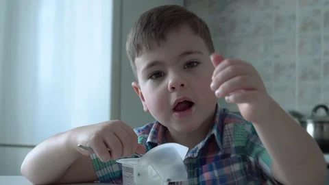 The boy is alone in the kitchen at the table Stock Footage 167590848