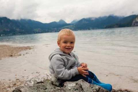 Boy at the Alpine lake. Stock Photos