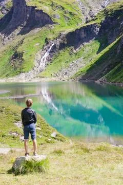 A boy at the alpine lake Stock Photos