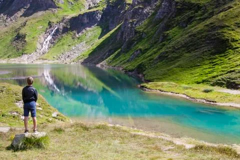 A boy at the alpine lake Stock Photos