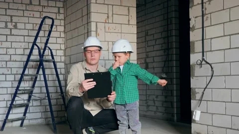 The boy and the father are thinking about what repairs to make in the room Stock Footage 238477230