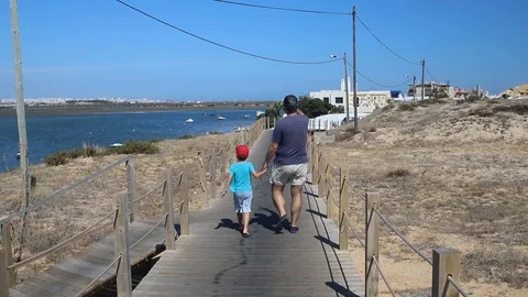 Boy and father walking close to the sea Video stock 116734603