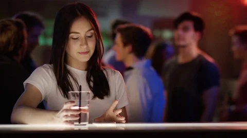 Boy and girl checking each other out in bar Stock Footage 84459155