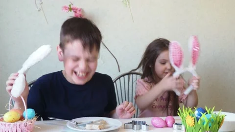 Boy and girl  cookies for easter, laughing.  Easter egg hunt. 库存影片 150904059