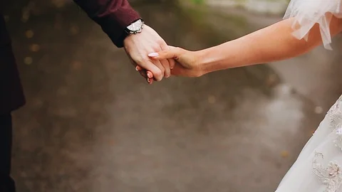 couple holding hands in rain