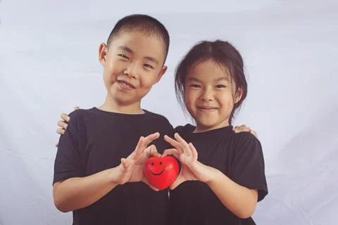 Boy and girl hold red heart Stock Photos
