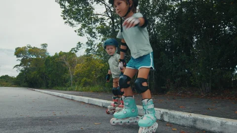 Boy and girl learn roller skating on the safety city area with no traffic and do Stock Footage 328172265