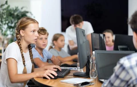 Boy and girl learning to work on computer in classroom Stock Photos