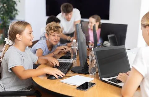 Boy and girl learning to work on computer in classroom Stock Photos